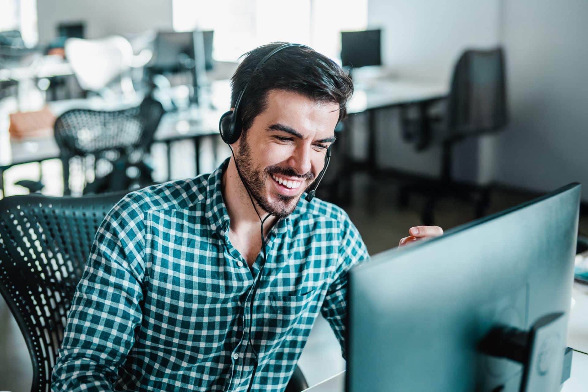 Ein junger Mitarbeiter führt ein Telefongespräch mit Kunden