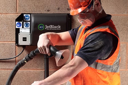 Wandmontierte JetBlack Safety Reinigungsstation entstaubt Arbeitskleidung mit Gebläseluft